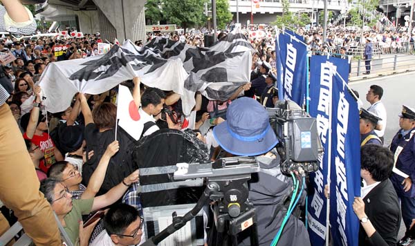 安倍首相の演説中に反自民の横断幕やプラカードを掲げる一団と競り合う党関係者（Ｃ）日刊ゲンダイ