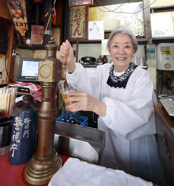 都内最古のサーバーでビールをつぐ澄子さん（Ｃ）日刊ゲンダイ