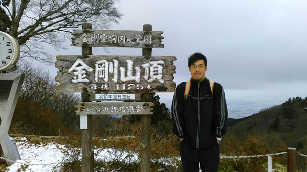 金剛山の頂きに立つファイナンシャルプランナーの藤原久敏さん（提供写真）