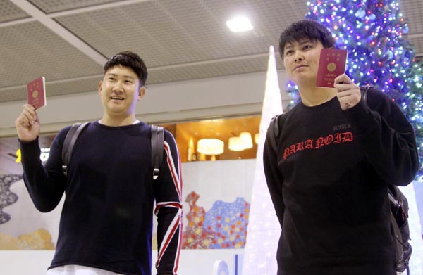パスポートを手に成田空港で取材に応じる菅野（左）と宮国（Ｃ）共同通信社