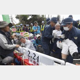 沖縄の民意は無視か（県民投票から一夜明け、米軍キャンプ・シュワブのゲート前から強制排除される座り込み男性。左端は沖縄平和運動センターの山城博治議長）／（Ｃ）共同通信社