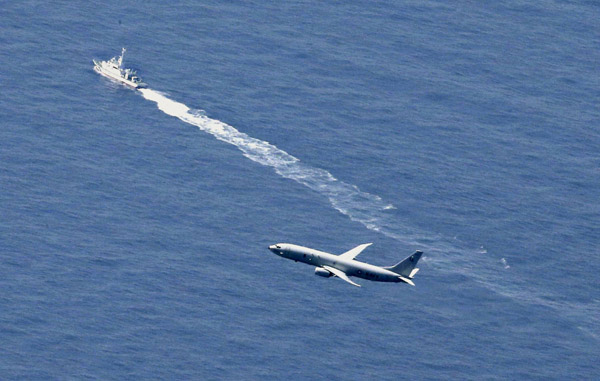 墜落した海域付近を捜索する海上保安庁の船舶（奥）と米軍機（Ｃ）共同通信社