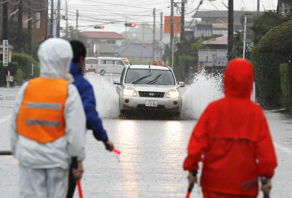 九州南部は猛烈な雨だった（大雨の影響で冠水した宮崎県都城市の道路を走る車）／（Ｃ）共同通信社