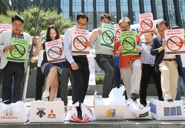 日本ブランドの名前をつけた箱を踏み潰し抗議する人たち（韓国、ソウル）／（Ｃ）ロイター