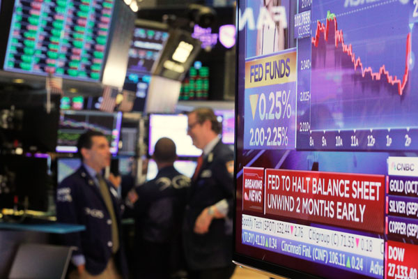 ニューヨーク証券取引所で利下げ発表がモニタに表示（Ｃ）ロイター