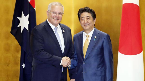 G20大阪サミットで握手するオーストラリアのモリソン首相（左）と安倍首相（Ｃ）共同通信社