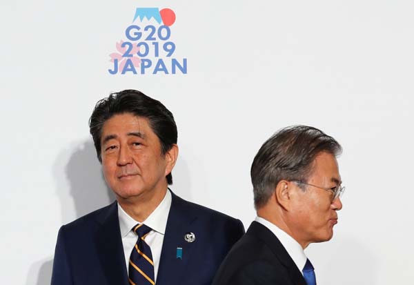 Ｇ２０大阪サミットで握手した後、すれ違う韓国の文在寅大統領（右）と安倍首相（Ｃ）ロイター