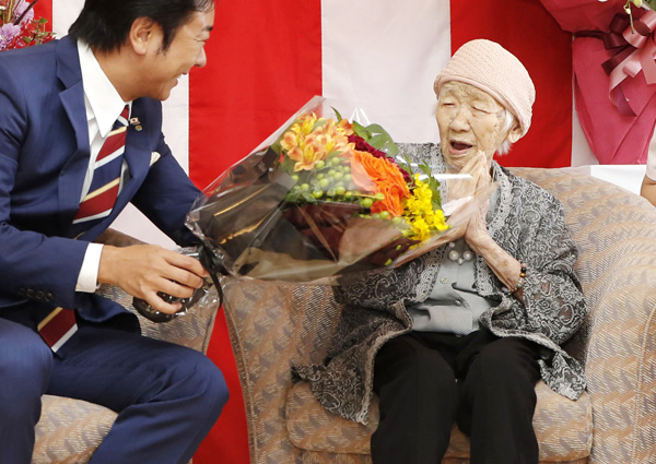 福岡市長（左）から花束を受け取る田中カ子さん（Ｃ）共同通信社