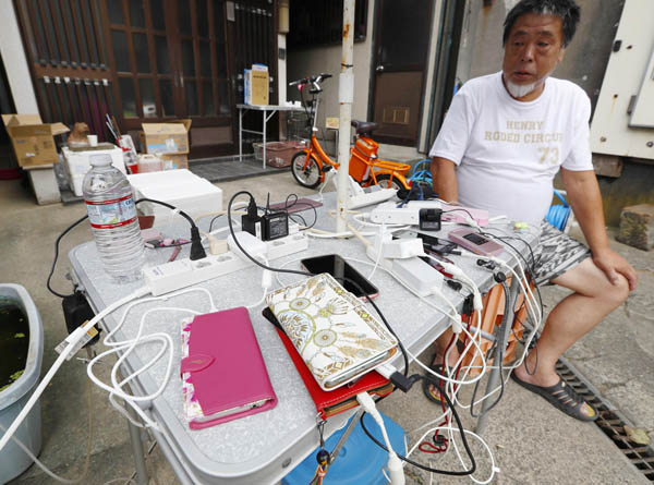 台風１５号による影響で停電が続く中、住民がガソリンと発電機を工面し設置した、携帯電話の充電所（Ｃ）共同通信社