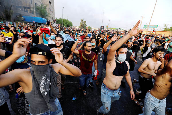 失業、乏しい公共サービス、政府の在り方に対して反スローガンを叫びながらデモをする若者たち（イラク、バグダット）／（Ｃ）ロイター