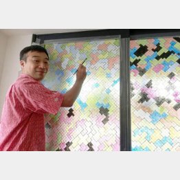 シェアハウスの窓を塗る内田勉さん（提供写真）