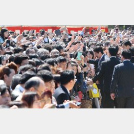 「桜を見る会」で次々に招待客とハイタッチをしてまわる安倍首相（Ｃ）日刊ゲンダイ