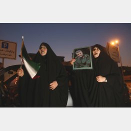 ソレイマニ司令官の写真を掲げるイランの女性（Ｃ）ロイター／WANA (West Asia News Agency）