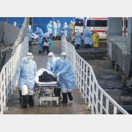 武漢市内の医療環境は劣悪（突貫工事で新設された「火神山医院」に新型肺炎患者を運び込む医療関係者ら）／（Ｃ）共同通信社