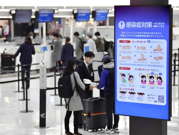 成田空港には感染症対策を呼びかけるモニターも（Ｃ）共同通信社