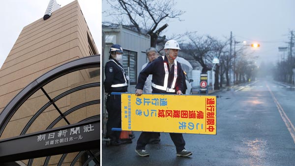 福島県富岡町の避難指示が一部解除され、設置してあった看板を撤去する警備員（右）／（Ｃ）共同通信社