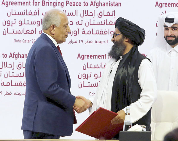 署名後に握手するタリバンのバラダル師（右）と米国のハリルザド・アフガニスタン和平担当特別代表（Ｃ）共同通信社