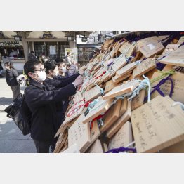 国公立大の２次試験の前期日程を前に、東京・湯島天神で合格祈願の絵馬を結ぶマスク姿の受験生（Ｃ）共同通信社