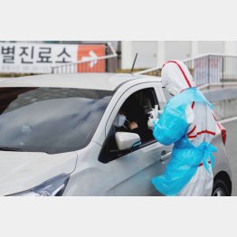 韓国の大邸にある大学医療センターで「ドライブスルー」検査をする防護服の医療スタッフ（Ｃ）ロイター