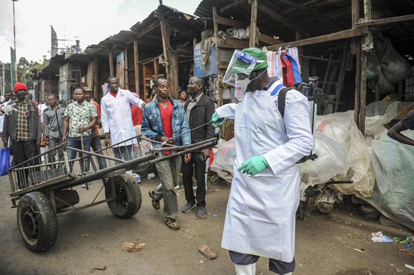 ケニアの首都ナイロビの屋外市場で、手押し車に消毒剤をかける保健省当局者（Ｃ）AP＝共同