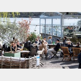 コロナ禍のなか、野外レストランで春の陽気やおしゃべりを楽しむ人たち（スウェーデン首都ストックホルム、２６日）　（Ｃ）ロイター／TT News Agency