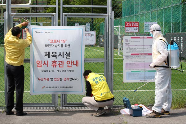 新型コロナウイルスの感染拡大で一時閉鎖の通知を取り外すソウル東にある城東区サッカー場関係者（Ｃ）ロイター