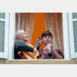 外出が原則禁止となったイタリア・ローマで、自宅の窓辺で楽器を演奏する人たち（Ｃ）ロイター＝共同