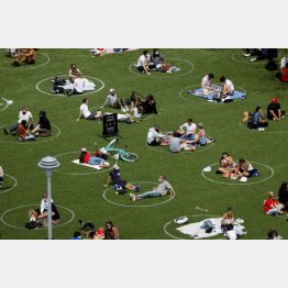 ソーシャル・ディスタンスを保つため、円で描かれた場所でくつろぐ人々（ニューヨーク・ブルックリンにある公園）／（Ｃ）ロイター