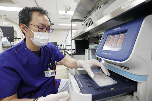 PCR検査方法は随分進化している（処理を終えた検体を「リアルタイムPCR検査装置」にかける臨床検査技師＝札幌市の北海道大病院）／（Ｃ）共同通信社