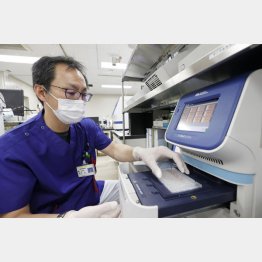 PCR検査方法は随分進化している（処理を終えた検体を「リアルタイムPCR検査装置」にかける臨床検査技師＝札幌市の北海道大病院）／（Ｃ）共同通信社