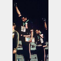 1968年メキシコ五輪の表彰台で、黒い手袋の拳を突き上げる金メダルのトミー・スミス（左）と銅メダルのジョン・カルロス（Ｃ）ロイター／Abaca Press
