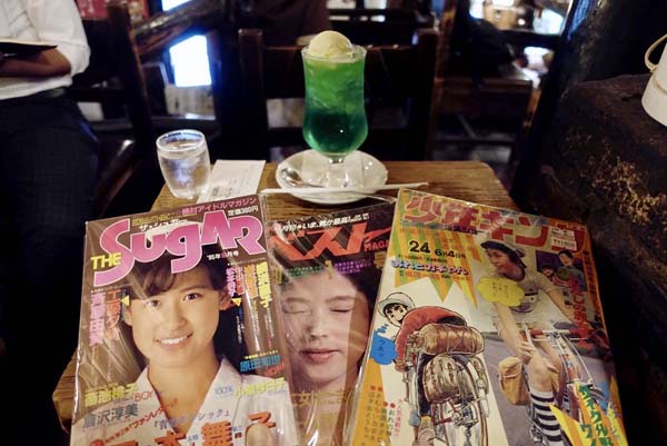 喫茶店で購入した雑誌を広げる（Ｃ）日刊ゲンダイ