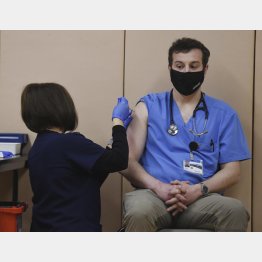 副作用も心配（米コロラド州で、新型コロナウイルス感染症ワクチンの接種を受ける医師（右、＝JERIEE・BENNETT／THE　GAZETTE・ＡＰ＝共同）