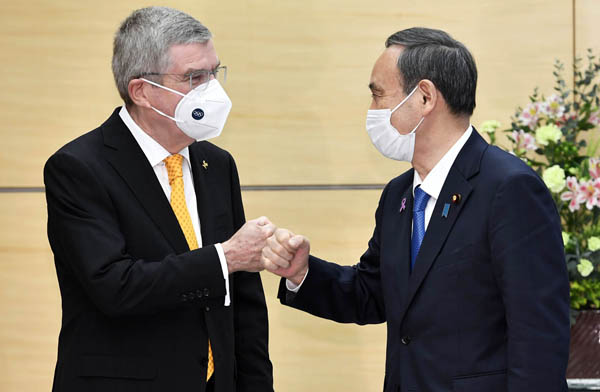 菅首相（右）はIOCのバッハ会長とグータッチしていたが、「デッドライン」はすぐそこ…（Ｃ）共同通信社