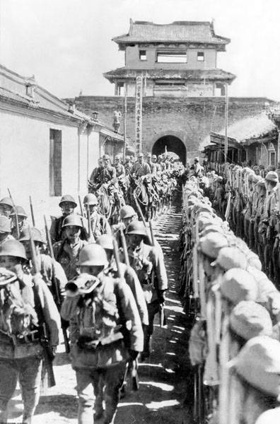 日中戦争。市の城壁を伝って、河北省保定に入城する日本軍兵士（INTERNATIONAL NEWS PHOTOS)