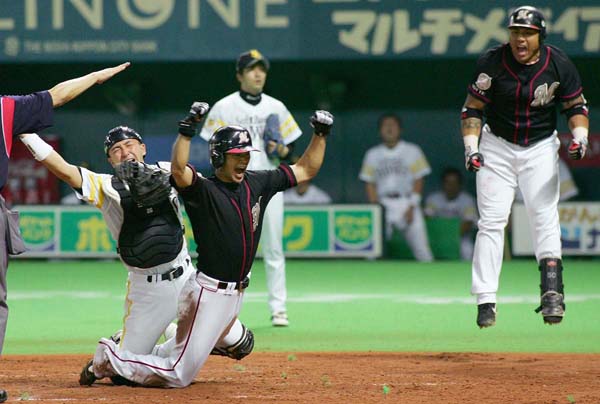 逆転のホームインでガッツポーズする福浦（Ｃ）日刊ゲンダイ