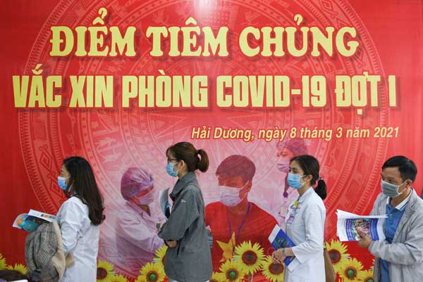 ベトナムでは工業労働者が優先対象（アストラゼネカ製のワクチン接種のために列をなすベトナムの公衆衛生従事者たち）／（Ｃ）ロイター