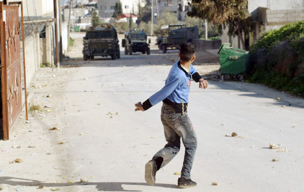 写真②ガザ地区でイスラエル軍に向かって石を投げる若者（Ｃ）ロイター