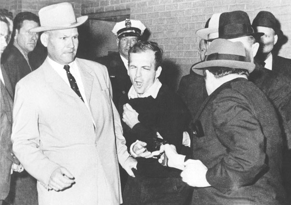 1963年11月24日、ケネディ米大統領の暗殺容疑者として逮捕されたリー・オズワルド（央）が事件から2日後、ダラス警察署で護送車に乗り込む際、ナイトクラブ経営者ジャック・ルビー（右手前）に射殺された（Ｃ）UPI=共同