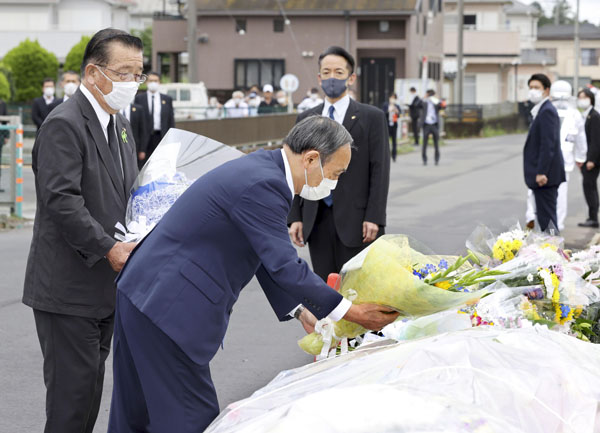 児童5人が死傷した事故現場の献花台に花を手向ける菅首相（手前）。左は千葉県八街市の北村新司市長（代表撮影）