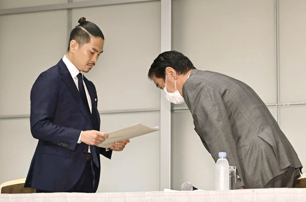 井岡（左）に謝罪文を渡し、頭を下げる永田理事長（Ｃ）共同通信社