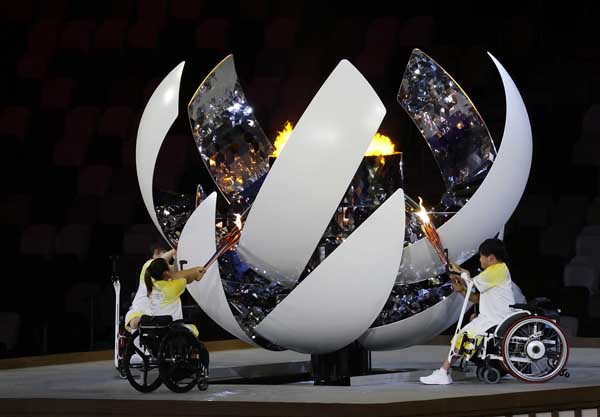パラリンピック開会式で聖火をともす上地結衣ら（Ｃ）日刊ゲンダイ