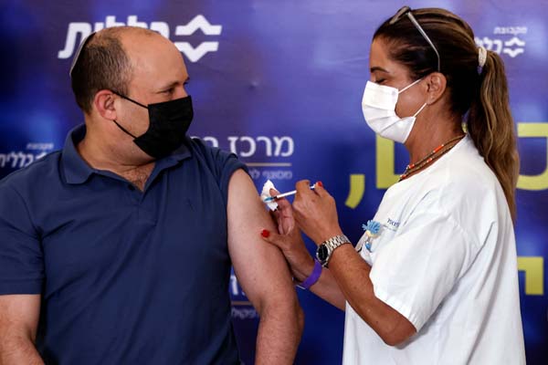 3回目のワクチン接種を受けるイスラエルのナフタリ・ベネット首相（Ｃ）ロイター