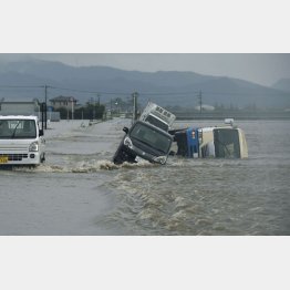 福岡県の大刀洗川から濁流があふれ、冠水した田んぼに転覆した車両(2019年7月)／（Ｃ）共同通信社