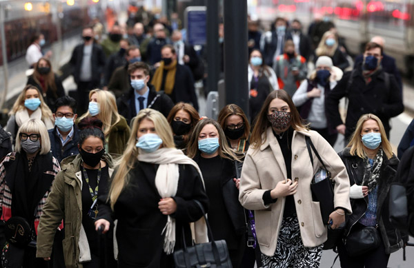 オミクロン株感染アウトブレイクのなか、朝の通勤ラッシュアワーでキングス・クロス駅を歩く人々＝英ロンドン（Ｃ）ロイター