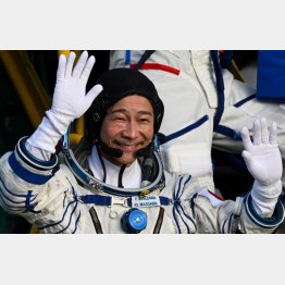 ８日、カザフスタンのバイコヌール宇宙基地で、宇宙船に乗り込む前に手を振る前澤友作氏（代表撮影・タス＝共同）