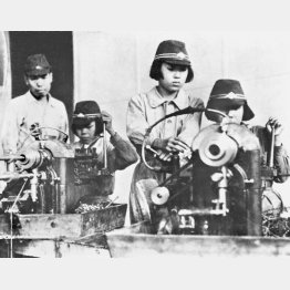 「女子挺身（ていしん）隊」の若い女性が勤労奉仕で工場などへ大量動員、戦闘帽をかぶって旋盤機械を操作する表情にも幼さが残る（1944年6月8日）／（Ｃ）共同通信社