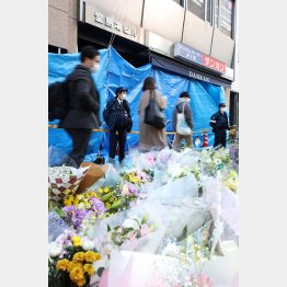 現場のビル前には多くの花が手向けられた（Ｃ）日刊ゲンダイ