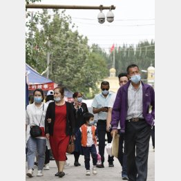 中国新疆ウイグル自治区カシュガル市。設置された監視カメラのなか、生活をする人たち（Ｃ）共同通信社