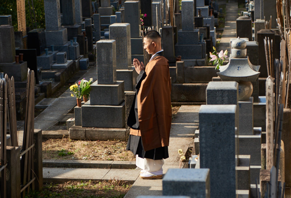 墓地で祈りをささげる西村宏堂さん（撮影）佐藤将希